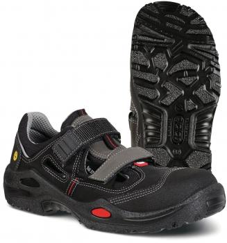 The image shows a black shoe with a sporty design. It features a padded collar, a wide Velcro strap, and a textured rubber sole with good grip.