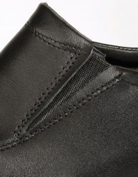 Das Bild zeigt einen Teil eines schwarzen Schuhs aus Leder. Der Schuh hat eine elastische Einsätze und feine Nähte, die ihm ein elegantes Aussehen verleihen.