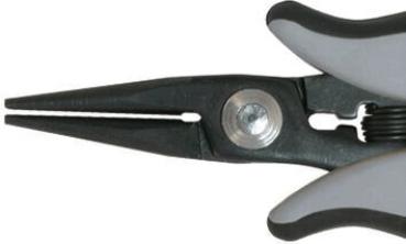 The image shows the tip of a pair of pliers with narrow, pointed jaws. It has a gray plastic handle and a black body. In the center, there is a screw for adjustment.