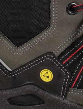 Das Bild zeigt einen Teil eines Schuhs, hauptsächlich in Grau und Schwarz. Es gibt rot gestreifte Details und eine gelbe ESD-Markierung. Die Materialien wirken robust und strapazierfähig.