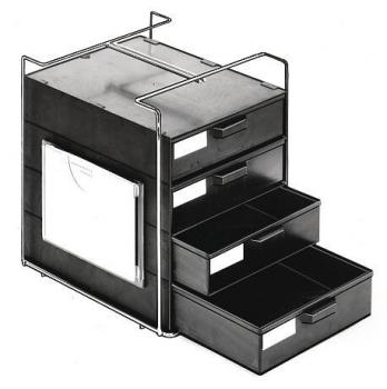 Das Bild zeigt einen kompakten, schwarzen Aktenschrank mit vier Schubladen. Oben ist eine flache Öffnung, darunter drei Schubladen in aufsteigender Größe. Der Schrank hat eine Drahtumrandung.