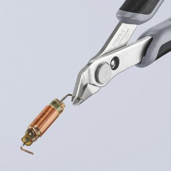 Das Bild zeigt eine Zange, die einen kleinen, zylindrischen Drahtkern hält. Der Kern ist kupferfarben und hat eine gewickelte Form, während die Zange graue Gummigriffe hat.