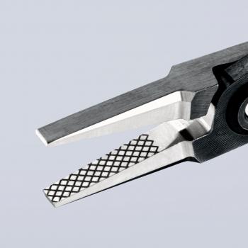 The image shows the tip of a pair of pliers. One of the jaws is flat and smooth, while the other has a textured, diamond-shaped surface. The background is light gray.