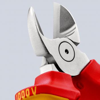 The image shows the cutting edge of an insulated pair of pliers. The blades are sharp and metallic, with a red handle that provides insulation for safety.