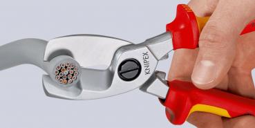 The image shows a hand holding a pair of pliers. The pliers have red and yellow handles and a silver stripping surface with a special hole pattern for cutting wire.
