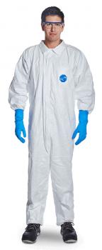 A person is wearing a white protective suit with long sleeves, blue latex gloves, and safety goggles. The background is neutral and dimmed.