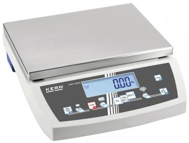 The digital scale has a flat, rectangular stainless steel surface on top. Beneath it is a display with blue digits and control buttons in various colors.