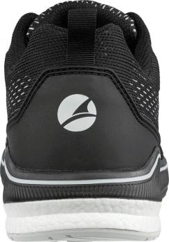 The image shows the rear view of a black sports shoe with a gray logo. The shoe has a textured surface and a white sole. There is a small loop at the top.