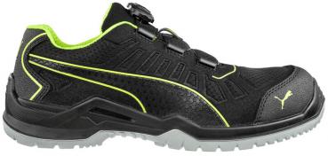 Der Schuh ist sportlich und schwarz mit grünen Akzenten. Er hat eine strukturierte Oberfläche, einen geflochtenen Schnürverschluss und eine robuste Gummisohle für guten Halt.