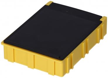 The image displays a rectangular box made of yellow plastic material. It has a smooth, black top and vertical grooves on the sides that provide stability.