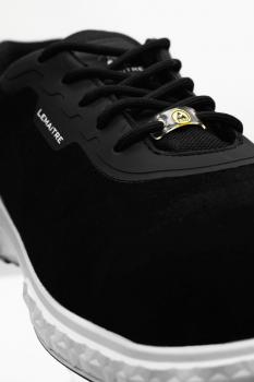 Der Schuh ist schwarz mit einer glatten Oberfläche. Er hat Schnürsenkel und eine weiße Gummisohle mit Struktur. Auf der Seite steht der Markenname "LDMATRE".