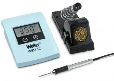 Das Bild zeigt ein Lötkolbeset. Darin ist ein digitaler Thermometer mit Temperaturanzeige, ein Lötkolben mit abgerundeter Spitze und ein Halter mit einem Reinigungsdraht.