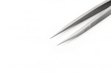 The image shows a calm, silver tweezer with pointed ends. The background is solid white. The surface of the tweezer is smooth with a fine grooved texture.