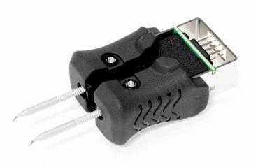 Das Bild zeigt einen USB-Adapter in Schwarz mit zwei metallischen Stiften. Der Adapter hat eine abgestufte Form und eine Standard-USB-Buchse, die auf der Oberseite sichtbar ist.