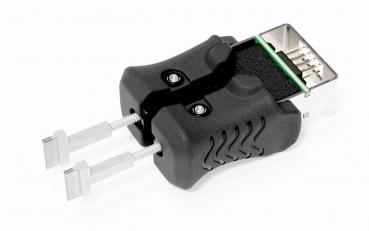 The image shows a black adapter with two silver pins protruding forward. At the top, a connection is visible, displaying a green and black area.