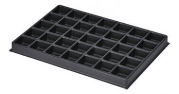 Das Bild zeigt eine schwarze Kunststoffform mit 36 kleinen quadratischen Fächern. Die Fächer sind gleichmäßig angeordnet und dienen wahrscheinlich zur Aufbewahrung oder zum Formen von Materialien.