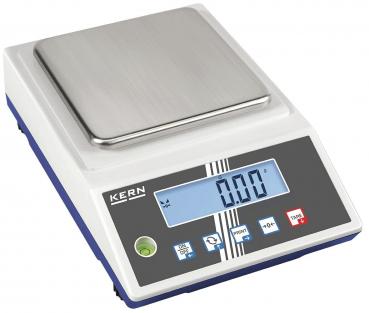 The image shows a digital scale with a flat, rectangular stainless steel plate on top. Below there is a display with blue backlighting and buttons in various colors.