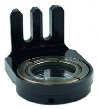 The image shows a black, metallic component with a round opening and three protruding elements. It has a smooth surface and is designed for mechanical connections.