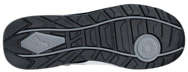 The image shows the sole of a sports shoe. It is black with tread patterns and special structures designed to provide good traction.