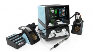 In the picture, there is a soldering device with two screens displaying temperatures. It has a soldering tip, a holder, and a stand for the soldering tin. Everything is in blue and black.