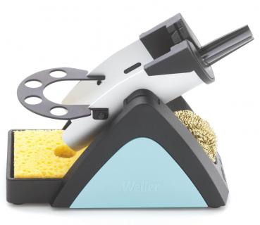 The image shows a soldering stand with a soldering tip, a sponge, and a brass cleaning brush. The stand has a triangular base and is designed in black and blue.