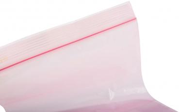Das Bild zeigt einen transparenten, wiederverschließbaren Plastiksack. Die obere Kante hat einen roten Streifen, der den Verschluss anzeigt. Der Sack ist teilweise gefüllt.