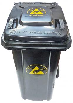 Der Abfallbehälter ist schwarz mit einem gelben Gefahrensymbol, das auf radioaktive Materialien hinweist. Er hat einen festen Deckel und Rollen für den Transport.