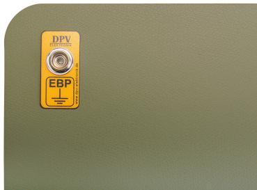 Das Bild zeigt eine grüne, gepolsterte Fläche mit abgerundeten Ecken. An der Oberfläche ist ein gelbes Etikett mit der Aufschrift "DPV" und "EBP" sowie einem silbernen Drehknopf angebracht.