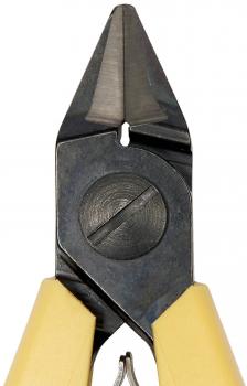 Das Bild zeigt eine Zange mit spitzen, schräg zulaufenden Schneiden. Der Körper ist aus glänzendem Metall, die Griffe sind gelb und ergonomisch geformt. Ein kleiner Kreis mit einer Rille ist in der Mitte.