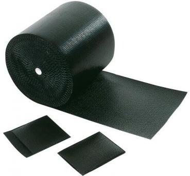 Das Bild zeigt eine schwarze Rolle mit rutschfestem Material, von der ein Stück abgerollt ist. Daneben liegen zwei kleinere Rechtecke aus dem gleichen Material.