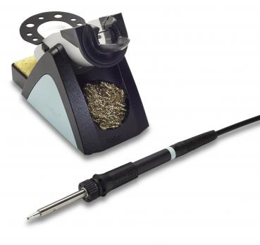The image displays a soldering iron kit. On the right is a soldering iron with a black handle and a metallic tip. On the left, there is a stand with a yellow sponge.