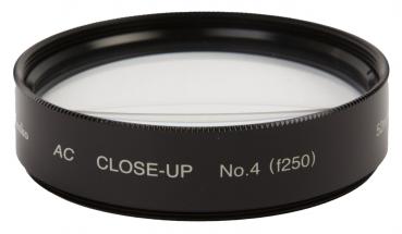 The image shows a black filter ring with a crystal-clear lens in the center. On the rim are white inscriptions "AC CLOSE-UP No.4 (f250)" that describe the type of filter.