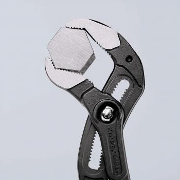 Das Bild zeigt eine Zange mit einem hexagonalen, metallischen Kopf. Die Zange hat griffige, schwarze Handflächen und ist geöffnet, bereit zum Greifen oder Festhalten von Objekten.