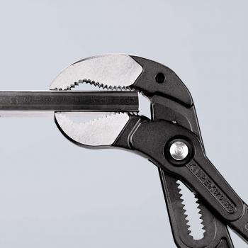 The image shows a pair of pliers with a long, narrow gripping surface. The pliers have a black plastic coating and metal gripping jaws with teeth for better grip.