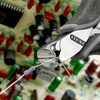 Das Bild zeigt eine Zange, die einen Widerstand hält. Im Hintergrund sind bunte elektronische Komponenten und Leiterbahnen auf einer Platine zu sehen.