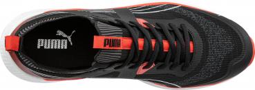 The shoe is sporty and has a black upper with red accents. The laces are black, and the Puma logo in orange is visible. The sole is light and textured.