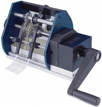 Das Bild zeigt eine manuelle Maschine mit einem Handgriff. Sie besitzt zwei Walzen und einen Einsatzbereich, in dem Papierstreifen verarbeitet werden. Der Mechanismus wirkt robust und funktional.
