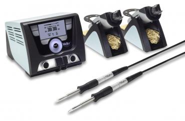 The image shows a soldering station with a control unit that has a display, as well as two soldering irons with individual holders. The holders contain solder or cleaning material.