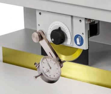 Das Bild zeigt eine Maschine mit einem runden, gelben Cutter und einem Messgerät. An der Seite befindet sich ein schwarzer Knopf und ein Sicherheitssymbol für Hände.