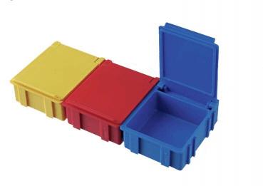 Das Bild zeigt drei kleine Kisten in verschiedenen Farben: eine gelbe, eine rote und eine blaue. Die gelbe und rote Kiste sind geschlossen, die blaue Kiste ist offen.