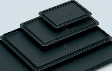 The image displays multiple black, rectangular trays in various sizes. They are stacked on top of each other, with the largest at the bottom and the smallest on top.