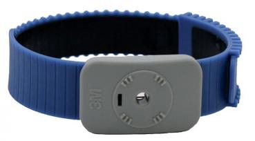 Das Bild zeigt ein Armband aus blauer Silikon, mit einer breiten, strukturierten Oberfläche. An einer Seite befindet sich eine graue, rechteckige Halterung mit einem zentralen Knopf.
