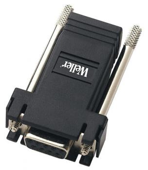 The image shows a black plug with a trapezoidal end that has five small, round contacts. On the top, it reads 