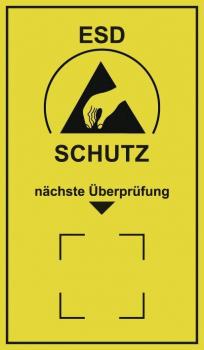 Das Bild zeigt ein gelbes Warnschild mit einem schwarzen Symbol: einem Handzeichen und einem Dreieck. Darunter steht "ESD SCHUTZ" und "nächste Überprüfung" in schwarzen Buchstaben.