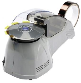 The image shows a gray machine type that looks like a small mixer. It has a transparent lid on top and a round, rotating disk with yellow markings.