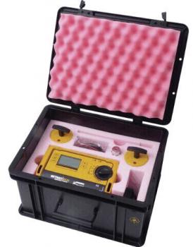 The image shows an open black suitcase with a yellow device and various accessories, surrounded by pink foam. The suitcase is sturdy and equipped for safe transport.