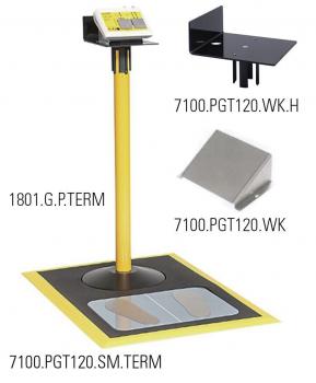 The image shows a yellow, upright column with a display on top. Below it is a square platform with round and oval imprints. The entire area is in yellow and black.