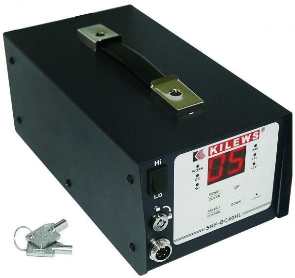 The image shows a compact, black device with a digital display that reads the number 05. It has a handle, rotary knobs, and two keys.