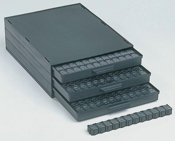 The image shows several black drawers stacked on top of each other. There are a total of four drawers, three of which are open. Next to the drawers, there is a small black bar.