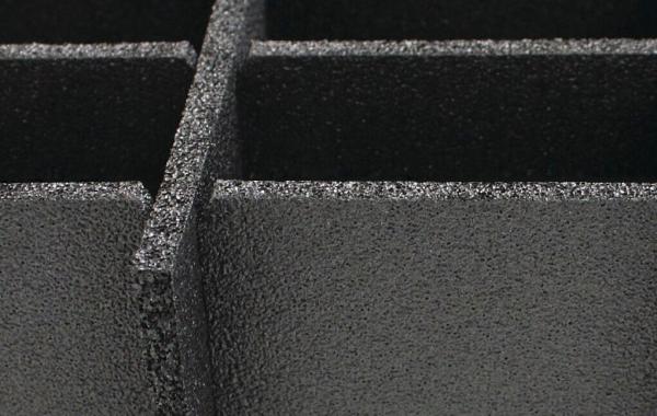 The image shows a black, textured surface with several rectangular indentations. The edges are sharply defined, conveying a sense of depth and dimension.